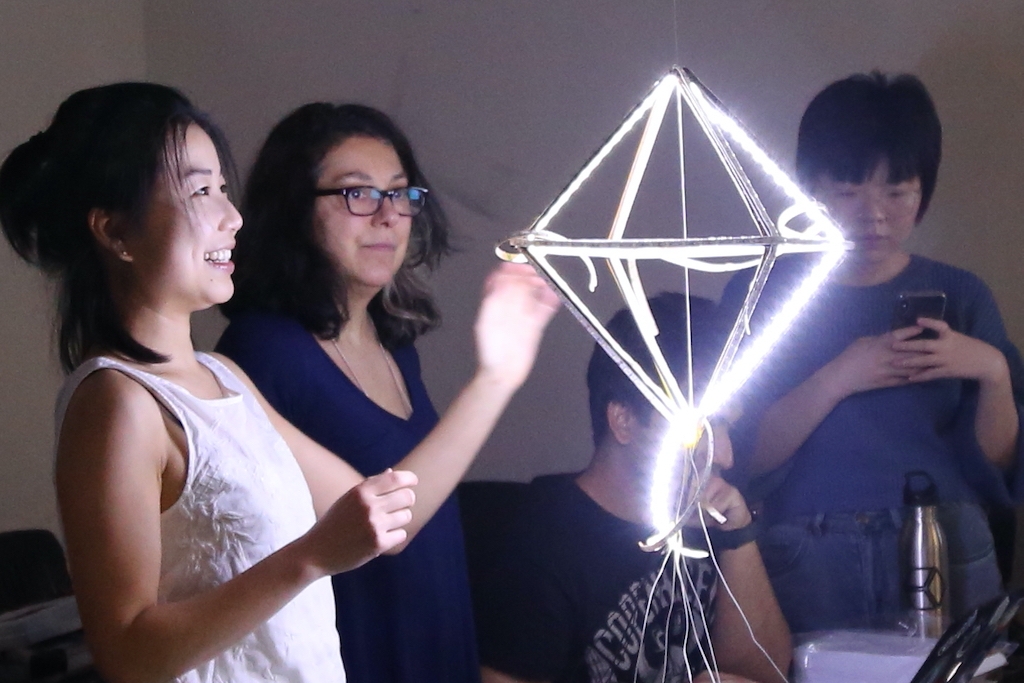 Students admiring a glowing diamond-shaped model